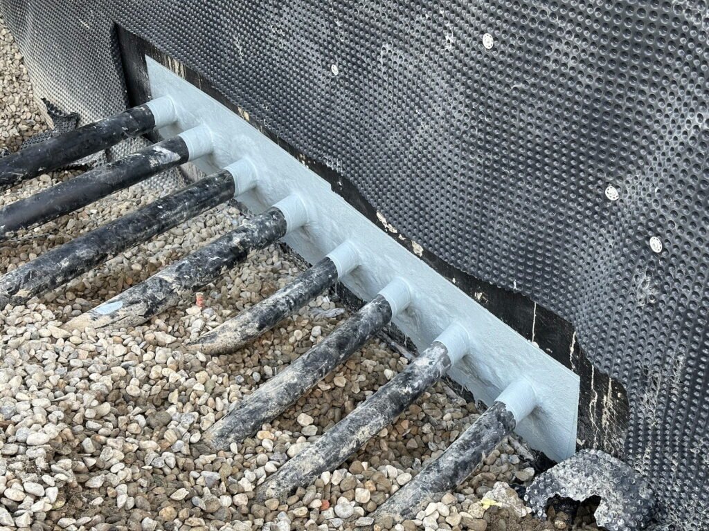Traitement d’un point singulier en étanchéité liquide avec raccords de réseaux techniques réalisé par Saphir Résine